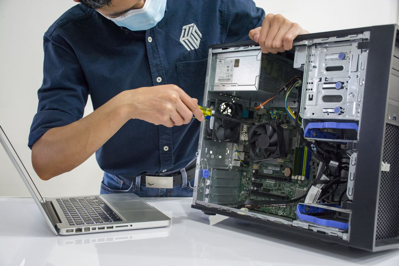Home A technician repairs a desktop computer in an indoor setting, illustrating tech maintenance.